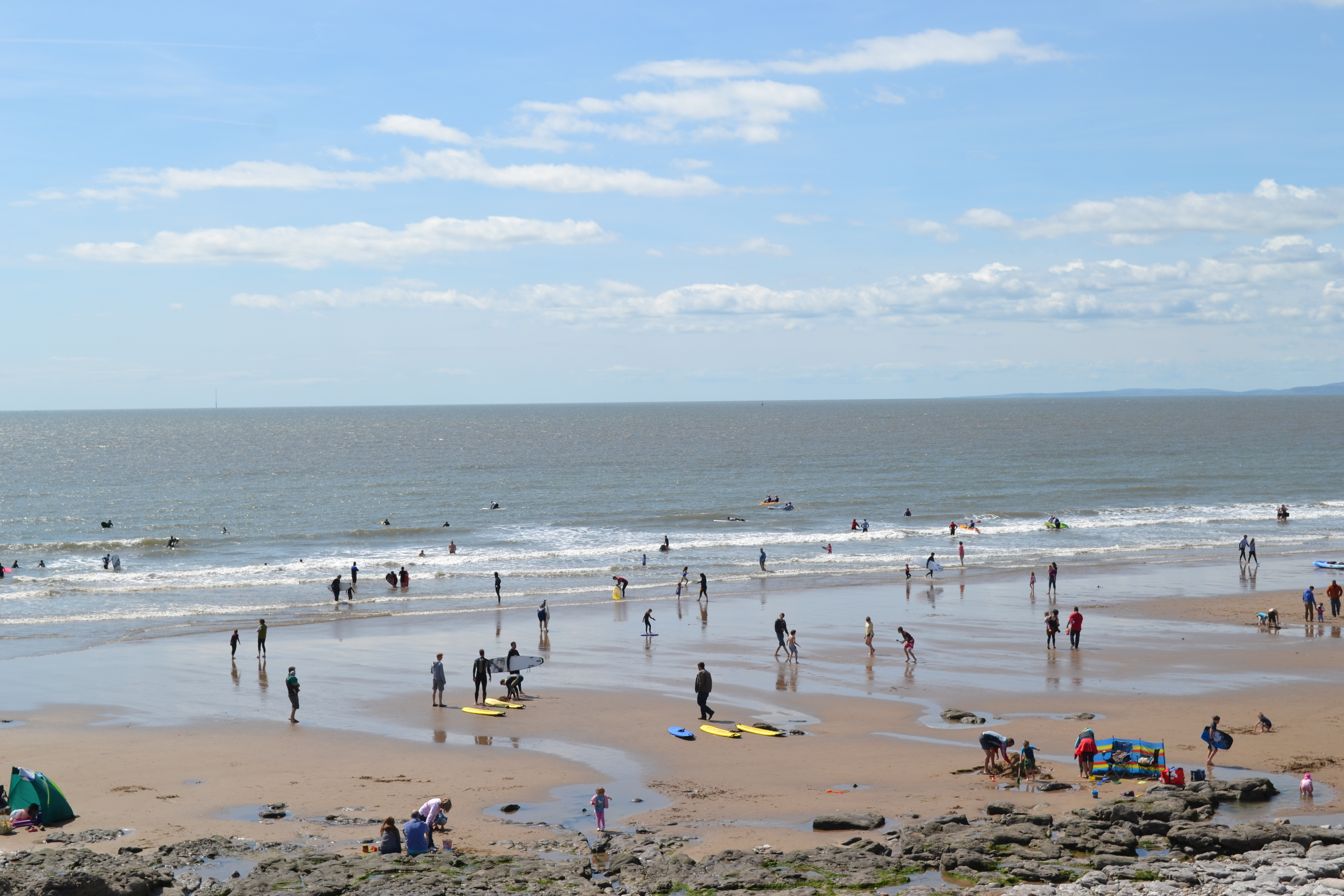 Ymwelwyr yn mwynhau'r heulwen yn Rest Bay ym Mhorthcawl.