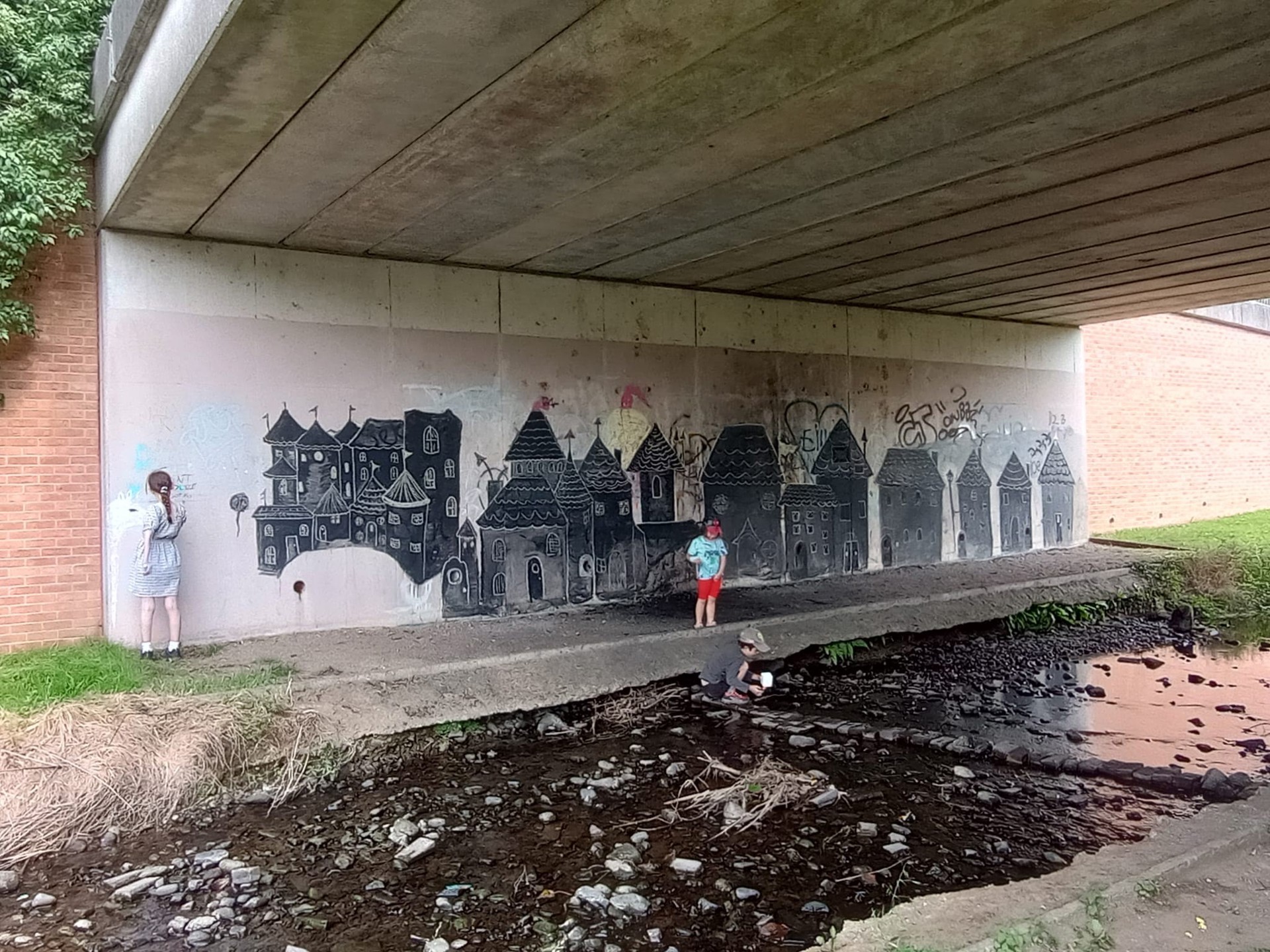 Yr isffordd gyda graffiti yn cael ei beintio drosodd gyda llun o dai tylwyth teg