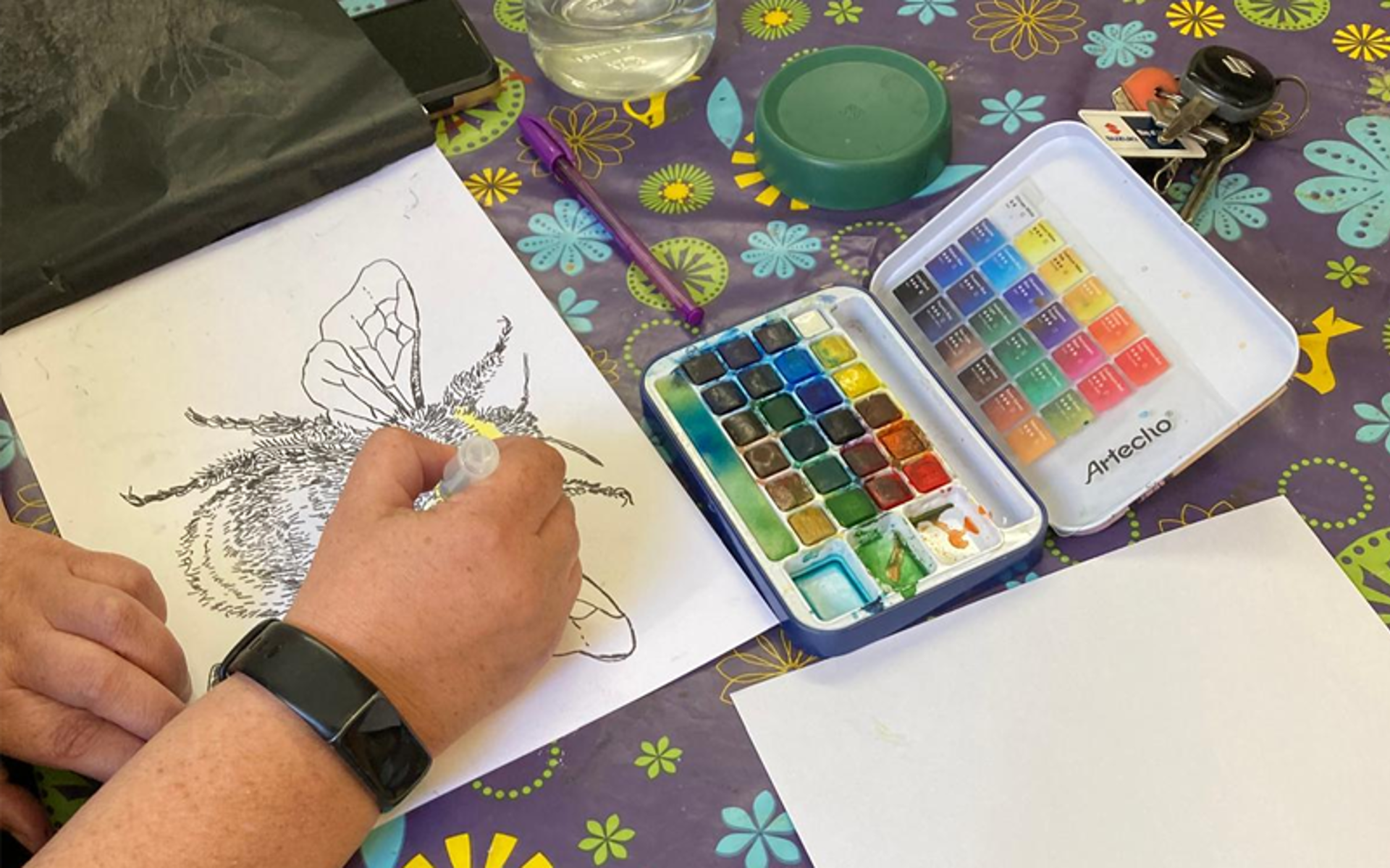Person painting a picture of a bee