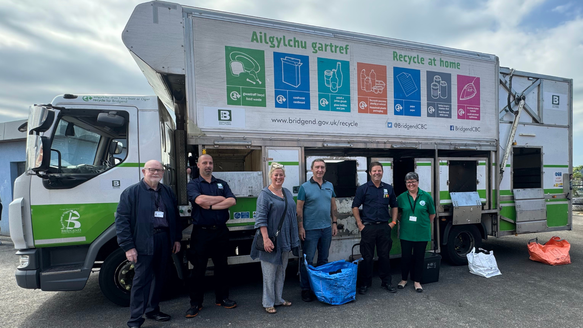 (Canol) Arweinydd y Cyngor, y Cynghorydd John Spanswick, yn ymuno â (Ch-Dd) Cynghorwyr Lleol Richard Williams a Melanie Evans, gyda chynrychiolwyr o Plan B Management Solutions a thîm Ailgylchu a Gwastraff y cyngor