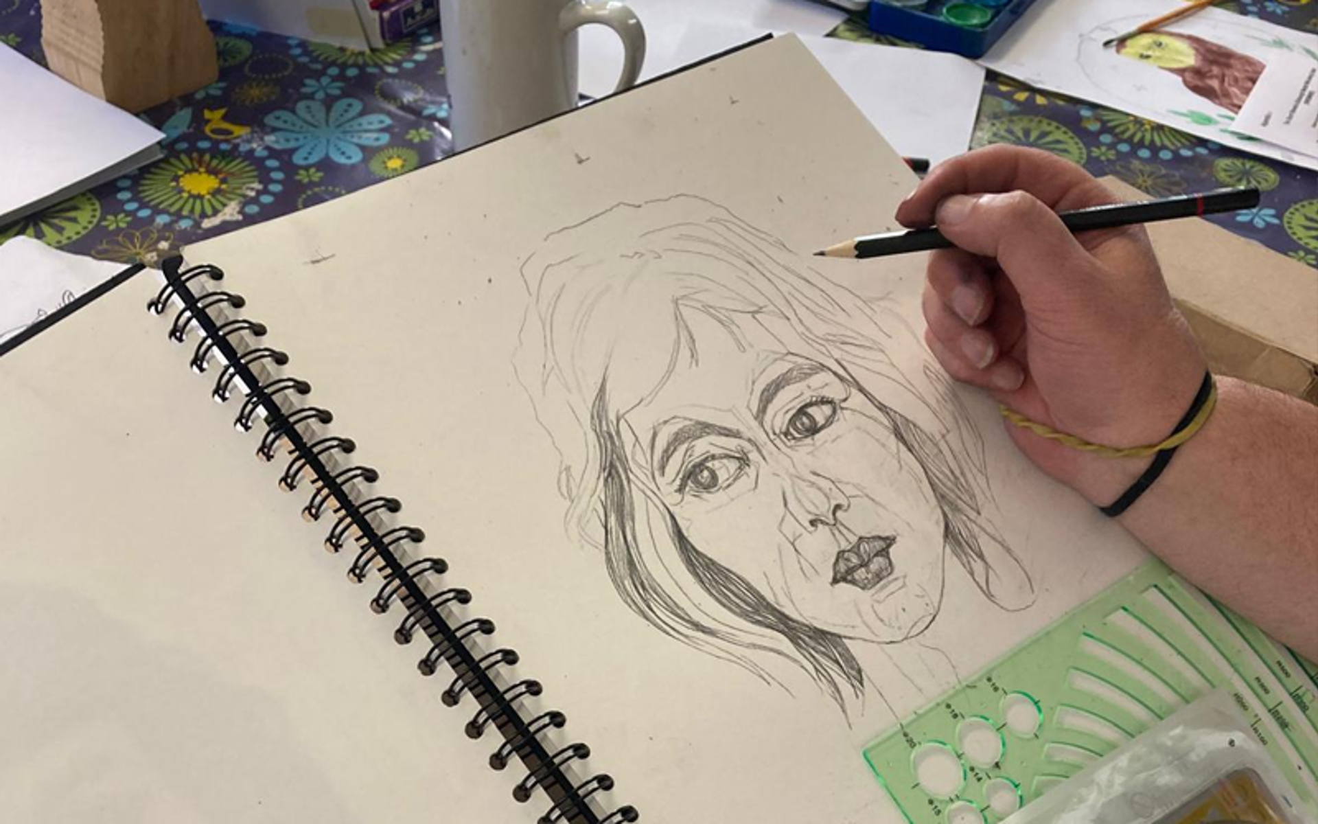 Person using a pencil to draw a portrait