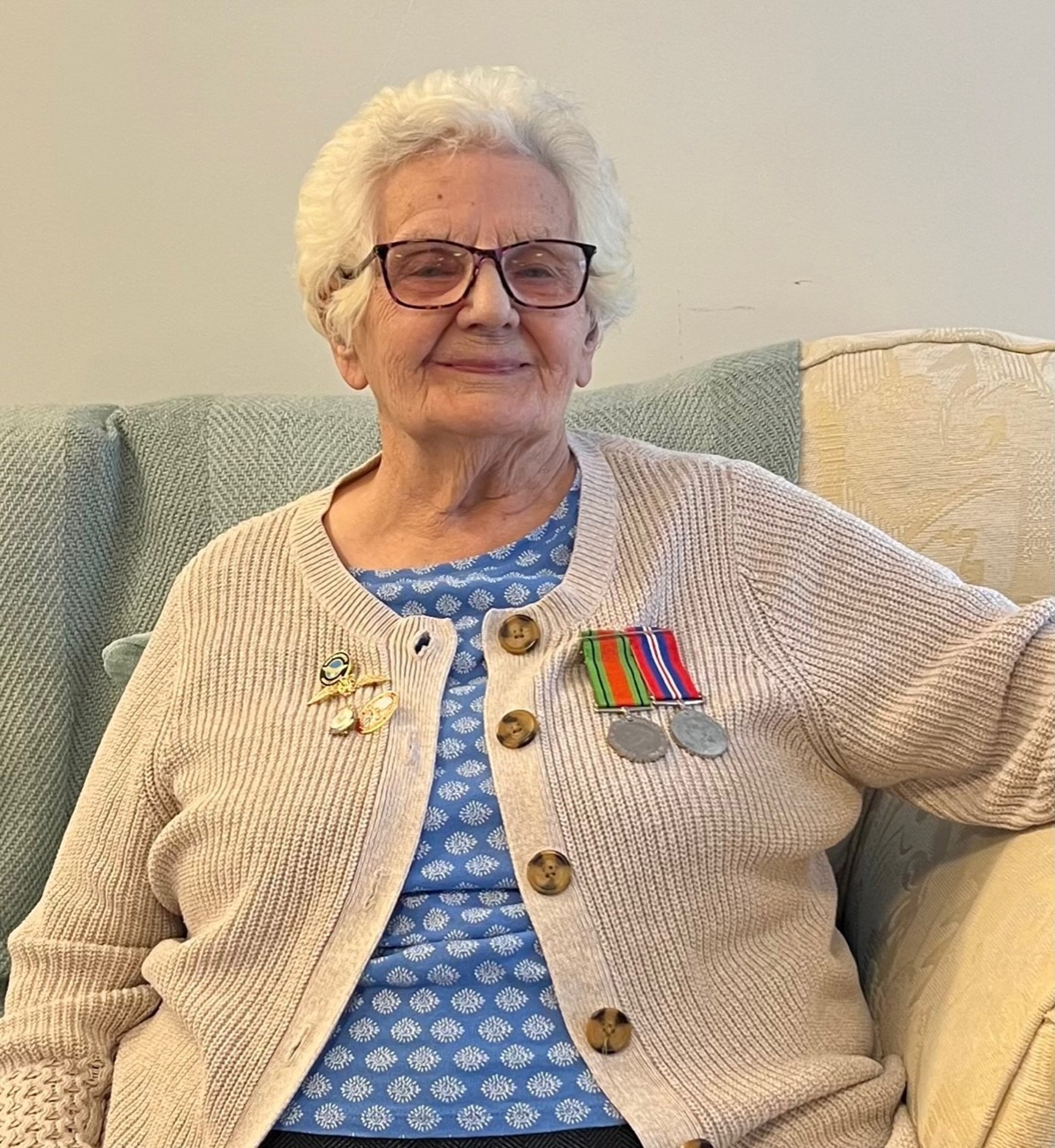 Margaret Rees yn gwisgo ei medalau yn Nhŷ Cwm Ogwr